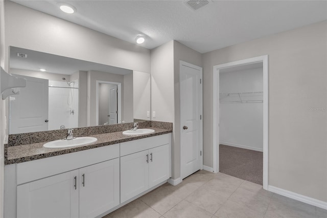 bathroom featuring a sink, baseboards, a shower, and visible vents