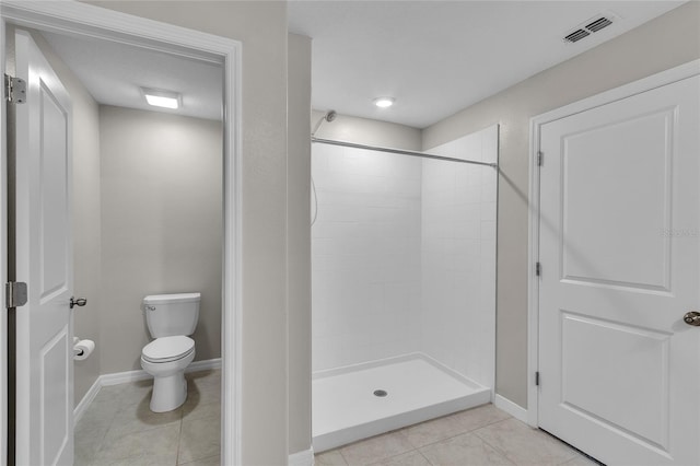 bathroom featuring toilet, tile patterned floors, baseboards, a shower stall, and visible vents