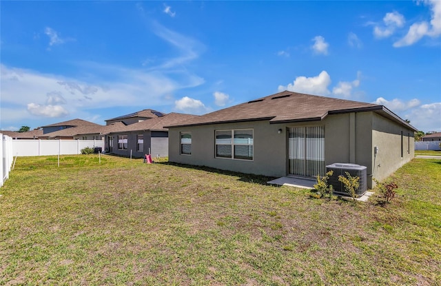 back of property featuring a lawn, stucco siding, fence, and cooling unit