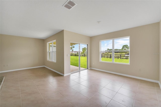 unfurnished room with light tile patterned floors, visible vents, and baseboards