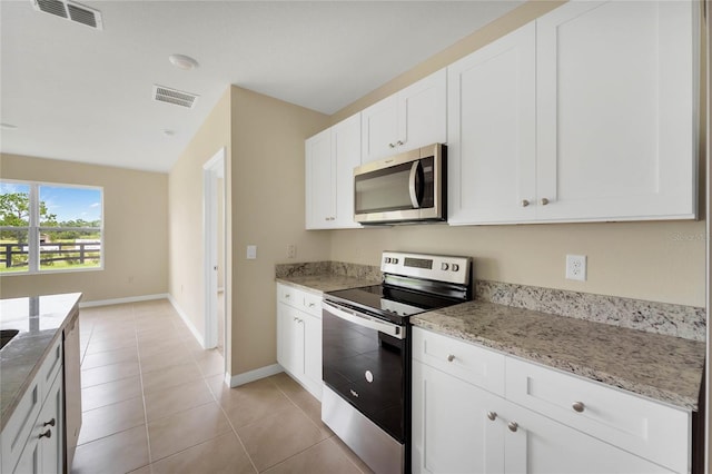 kitchen with baseboards, visible vents, stainless steel appliances, and white cabinets