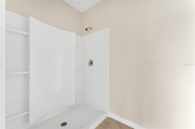 bathroom with a stall shower and tile patterned floors