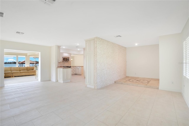 unfurnished living room featuring light tile patterned floors, recessed lighting, and visible vents