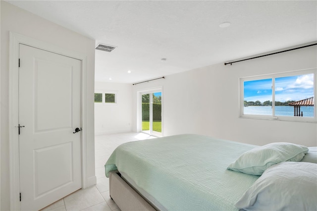 bedroom with access to exterior, visible vents, a water view, recessed lighting, and light tile patterned flooring