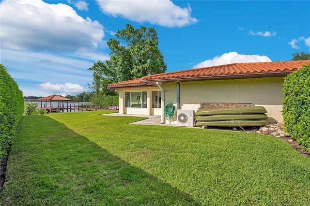 back of house featuring a gazebo, ac unit, stucco siding, and a yard