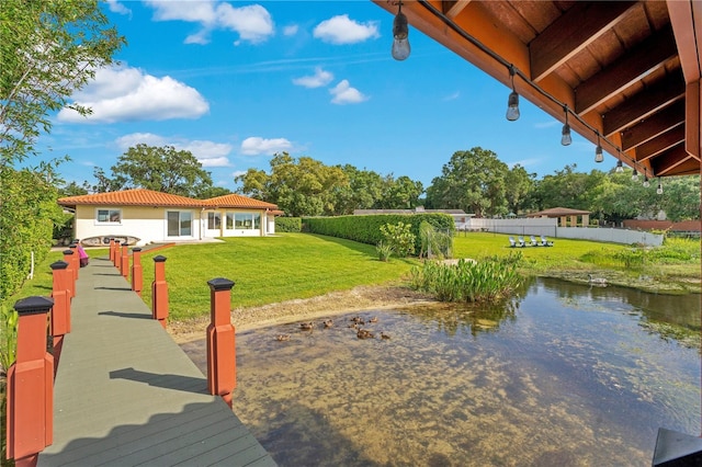 dock area featuring a lawn and fence