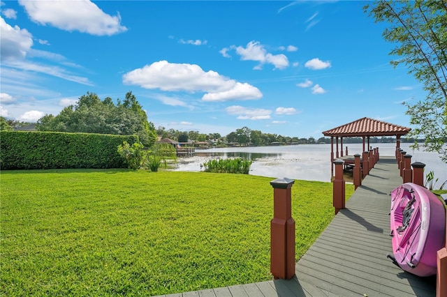 view of dock with a gazebo, a water view, and a yard