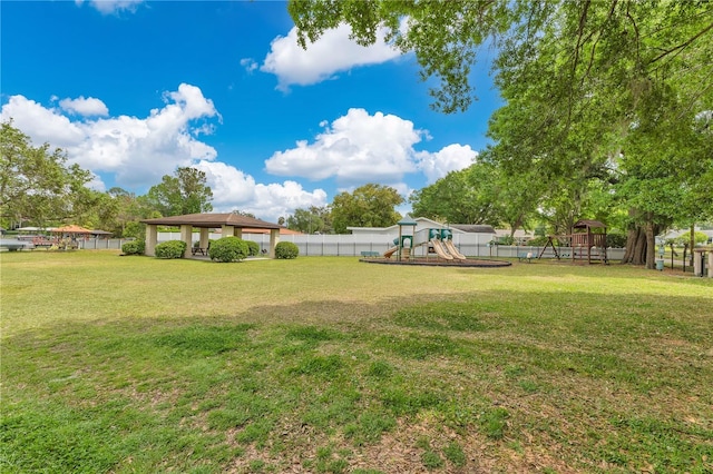 view of yard with a playground, fence, and a gazebo