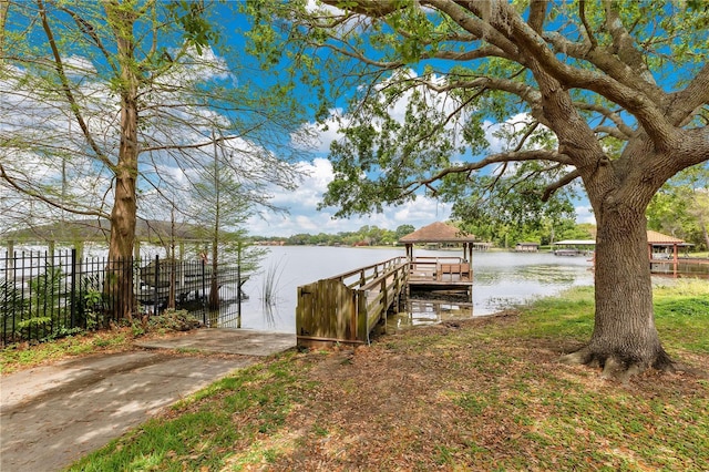 dock area featuring fence and a water view