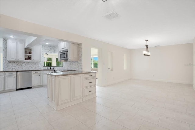 kitchen featuring visible vents, appliances with stainless steel finishes, open shelves, a sink, and a wealth of natural light
