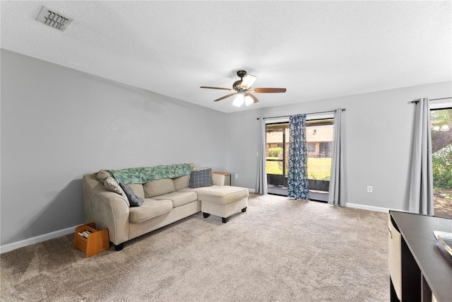 living room featuring ceiling fan, carpet floors, baseboards, and a textured ceiling