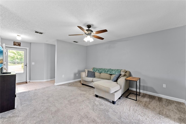 carpeted living room with ceiling fan, a textured ceiling, and baseboards