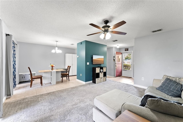 living room with light carpet, ceiling fan, a textured ceiling, light tile patterned floors, and a chandelier