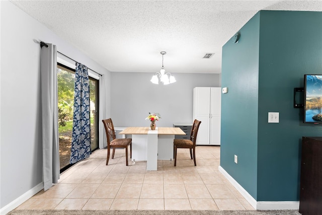 dining room featuring a chandelier, a textured ceiling, light tile patterned floors, and baseboards