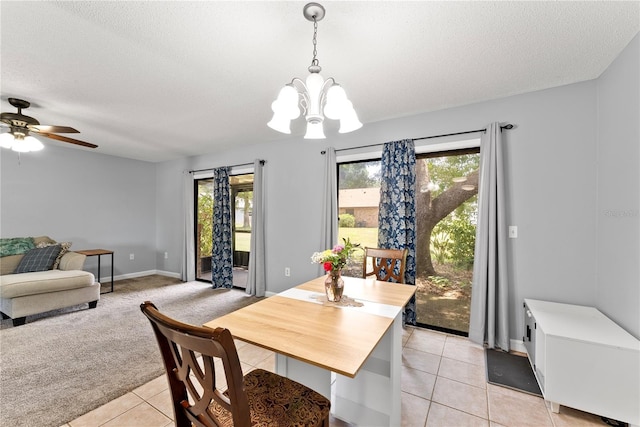 dining room with plenty of natural light, a chandelier, light tile patterned flooring, a textured ceiling, and ceiling fan