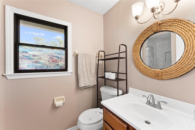 bathroom with toilet, vanity, and baseboards