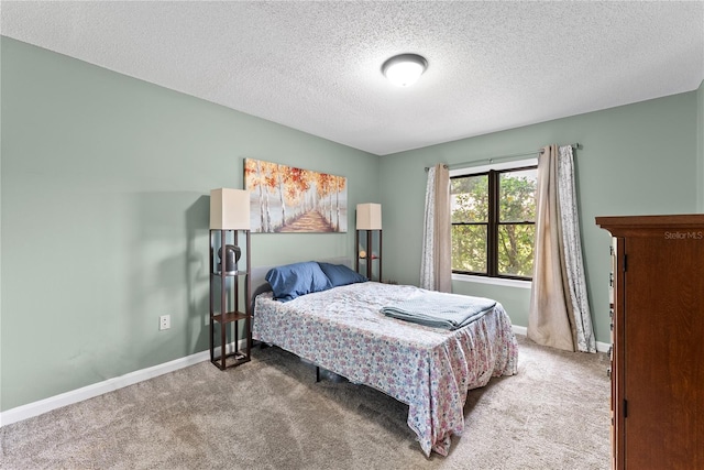 carpeted bedroom featuring a textured ceiling and baseboards