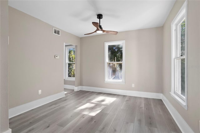 unfurnished room with baseboards, a ceiling fan, and a wealth of natural light