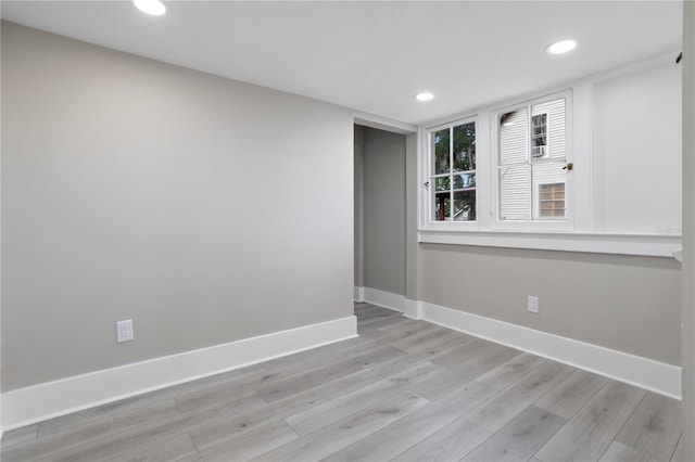 empty room with recessed lighting, baseboards, and light wood finished floors