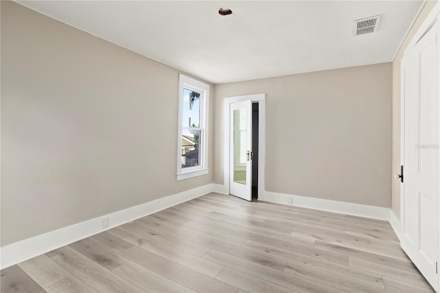 empty room with baseboards, visible vents, and light wood-style flooring