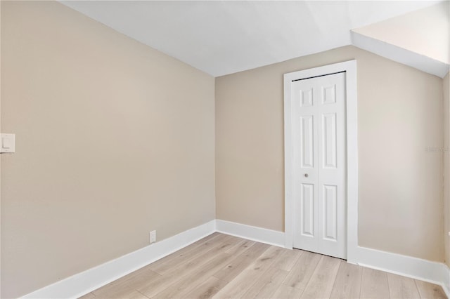 bonus room with light wood-type flooring, baseboards, and vaulted ceiling