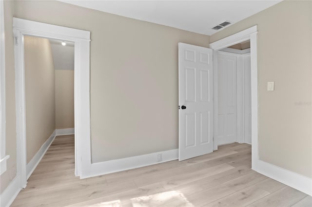 unfurnished bedroom featuring light wood-style floors, baseboards, and visible vents