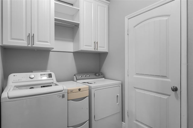 clothes washing area with cabinet space and washer and clothes dryer