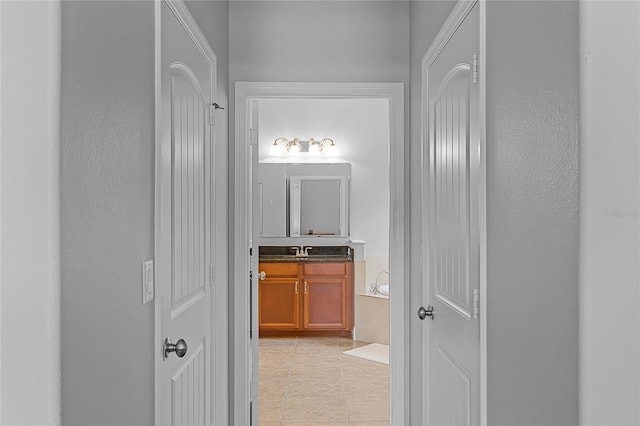 hallway featuring a sink and light tile patterned floors