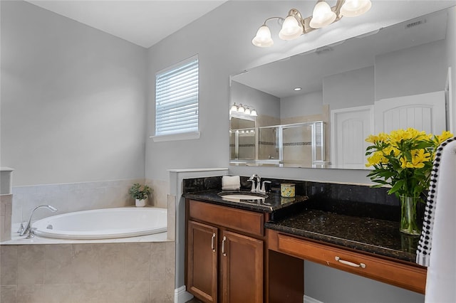 bathroom featuring vanity, visible vents, a bath, and a stall shower