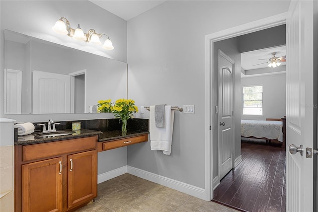 bathroom with baseboards, ceiling fan, vanity, and ensuite bath