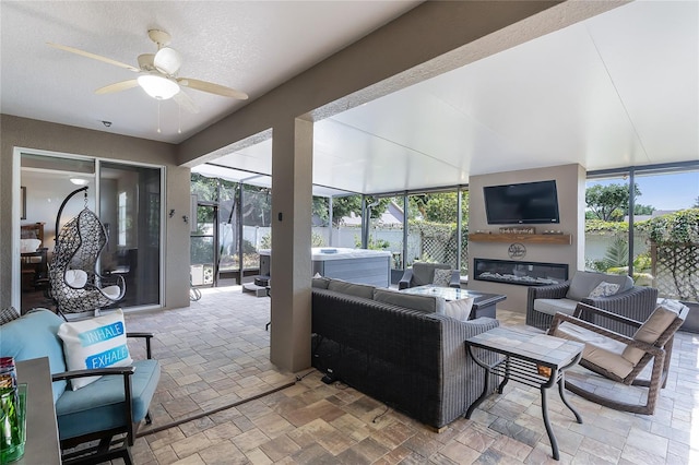view of patio / terrace featuring a lanai, fence, outdoor lounge area, and a ceiling fan
