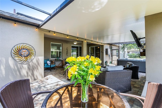 exterior space featuring outdoor dining space, ceiling fan, and a hot tub