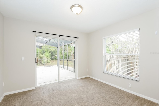 carpeted empty room featuring a healthy amount of sunlight and baseboards