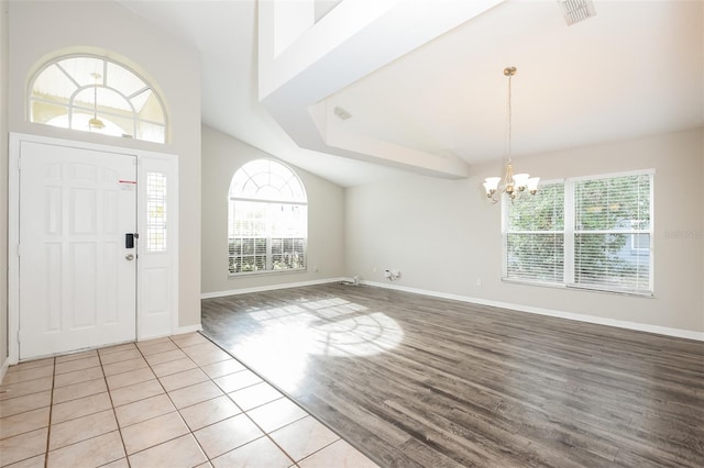 entryway with a chandelier, visible vents, a wealth of natural light, and light wood finished floors