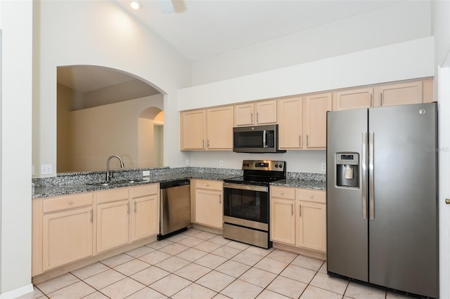 kitchen with light tile patterned flooring, light brown cabinetry, a sink, and stainless steel appliances