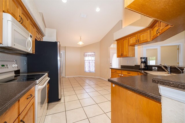 2924 Jebidiah Loop, Saint Cloud, FL 34772 - kitchen featuring white appliances, a sink, plenty of natural light, light tile patterned floors, and lofted ceiling