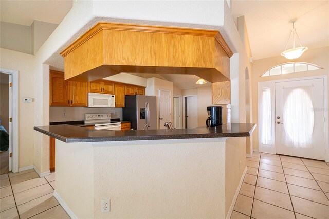 2924 Jebidiah Loop, Saint Cloud, FL 34772 - kitchen with white appliances, light tile patterned floors, dark countertops, a peninsula, and baseboards