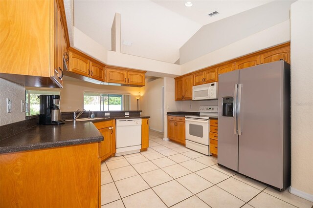 2924 Jebidiah Loop, Saint Cloud, FL 34772 - kitchen featuring white appliances, a sink, lofted ceiling, dark countertops, and light tile patterned floors