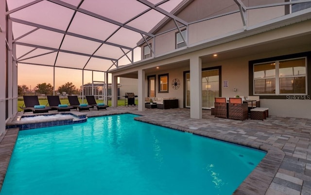 view of pool with a patio, a lanai, an outdoor living space, and grilling area