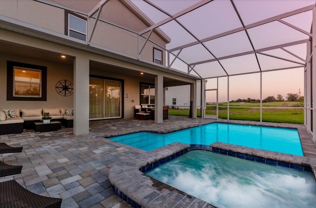 view of swimming pool with a patio area, a pool with connected hot tub, an outdoor living space, and glass enclosure