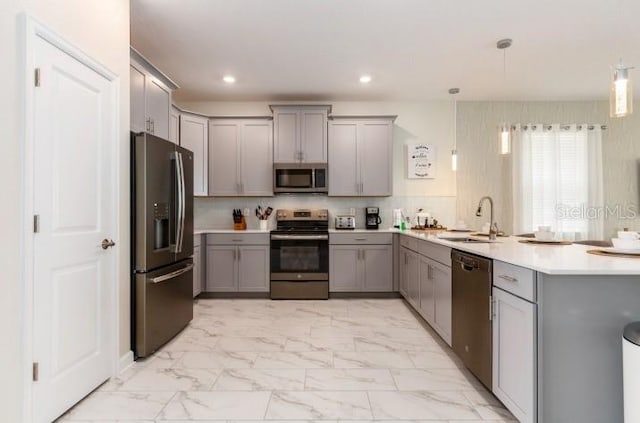 kitchen with marble finish floor, a sink, a peninsula, stainless steel appliances, and gray cabinets
