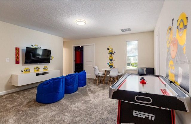 playroom with a textured ceiling, visible vents, baseboards, and carpet floors
