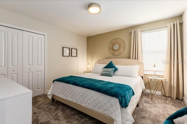 bedroom with baseboards, carpet flooring, and a closet