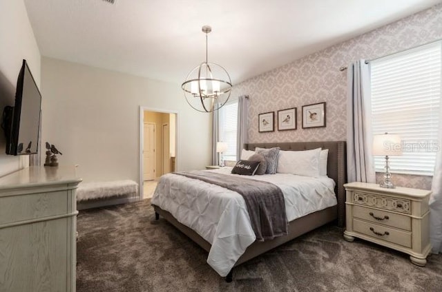 bedroom with dark carpet and a chandelier