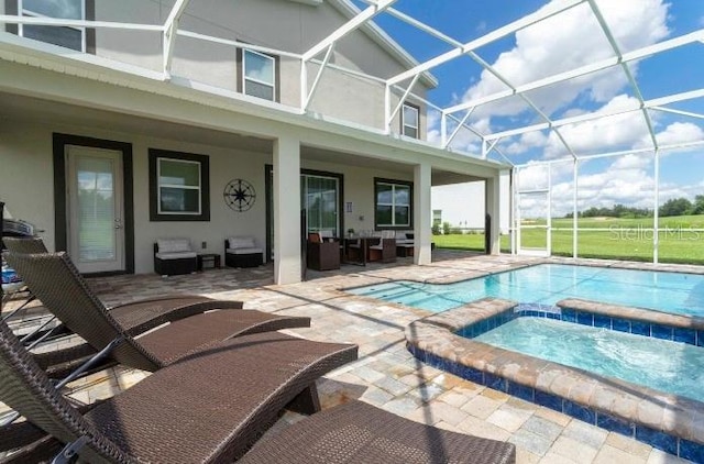 view of swimming pool featuring a patio, a pool with connected hot tub, an outdoor living space, and glass enclosure