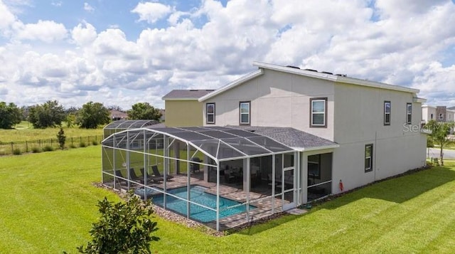 back of property with a yard, stucco siding, a fenced in pool, and glass enclosure