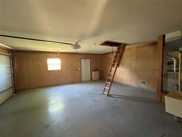 6042 Wade St, Leesburg, FL 34748 - garage with visible vents, a garage door opener, and wooden walls