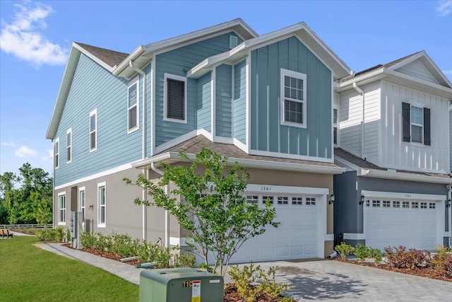 townhome / multi-family property featuring concrete driveway, a garage, and board and batten siding