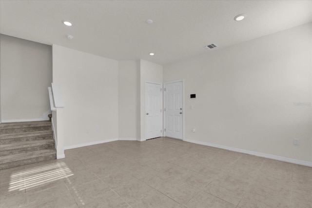 unfurnished room featuring stairway, visible vents, and recessed lighting