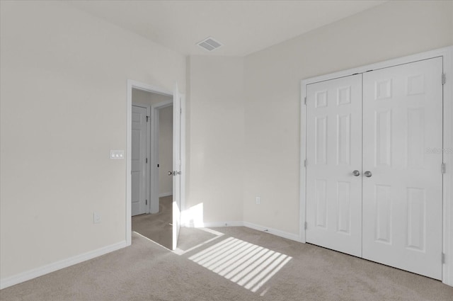 unfurnished bedroom featuring carpet flooring, a closet, visible vents, and baseboards